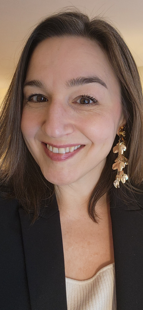 Two smiling women pose closely together in a black-and-white photo, showcasing warmth and friendship. The image captures a joyful moment.